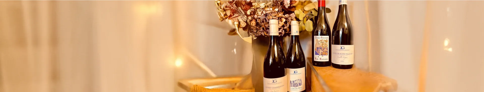 Quatre bouteilles de bourgogne rouge sur une étagère en bois